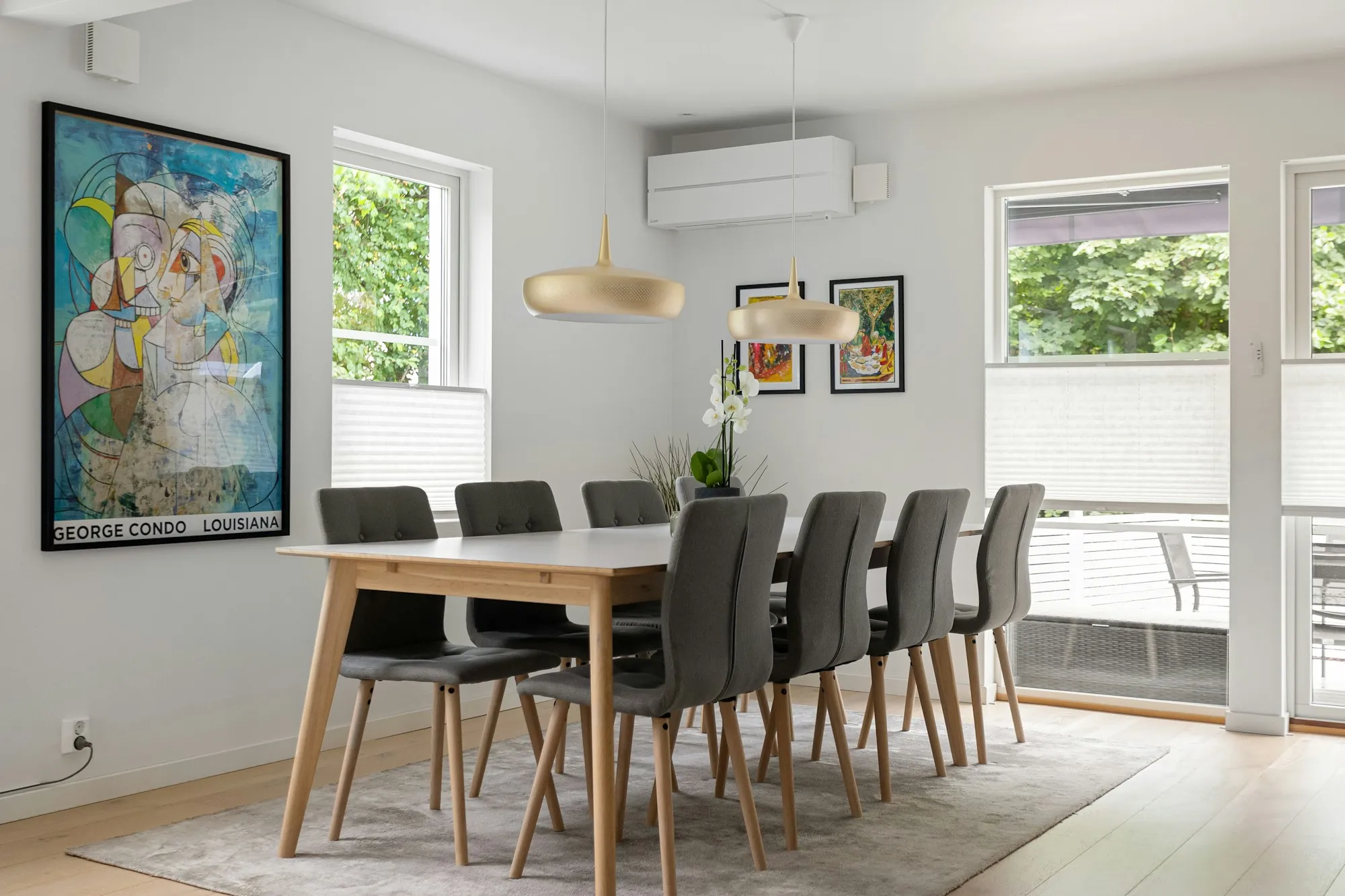Dining room with a light wood table and colorful wall art